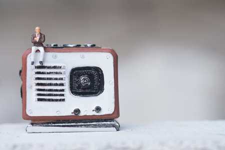 Miniature people sitting on radio retro. Concept of good old memories radio transistor in present day.の写真素材