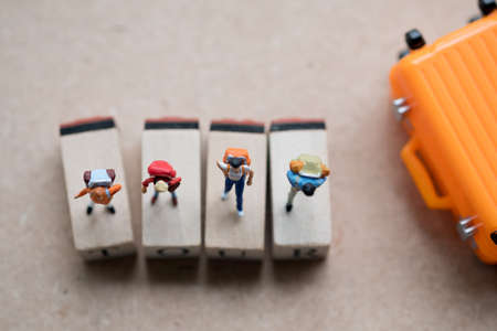 Group miniature traveler and hiker backpack standing on wooden tag with suitcase for the tourist and adventure around the world. Travel and tour conceptの写真素材