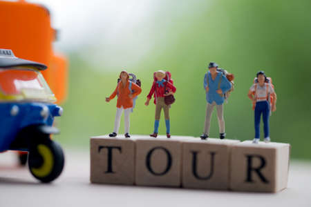 Miniature people : Traveler with backpack standing on wooden word TOUR with nature background, Concepts of travel and adventure in Thailand. Business travel conceptの写真素材