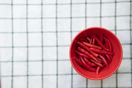 Red hot chili peppers in red bowl, ready to cook