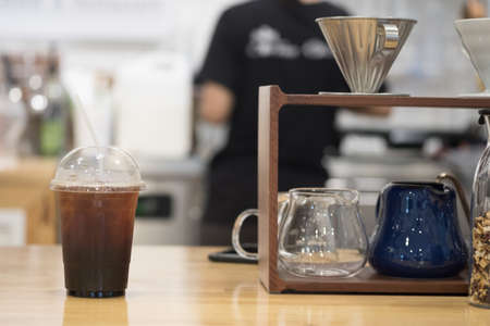 Ice black coffee or long black coffee in plastic cup put on coffee barの写真素材