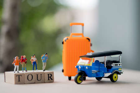 Group miniature traveler and hiker backpack standing on wooden text TOUR with suitcase for the tourist and adventureの写真素材
