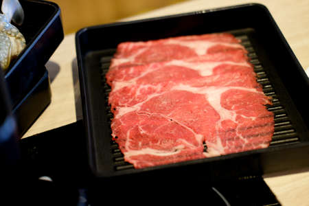 Raw freshly prepared sliced beef for hot pot and Japanese sukiyakiの写真素材
