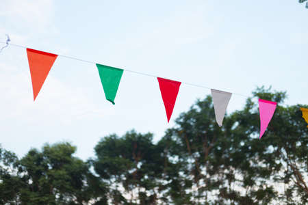 Triangular flags hanging on the sky at an outdoor in festivalの写真素材