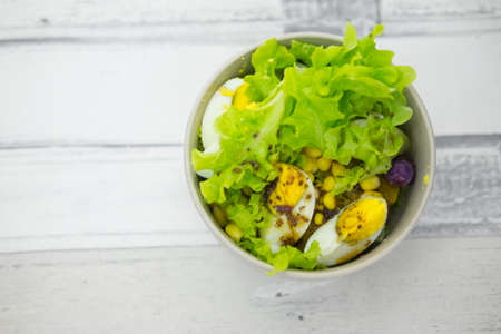 Fresh lettuce salad with yam and boiled egg with salad dressing. Healthy food conceptの写真素材