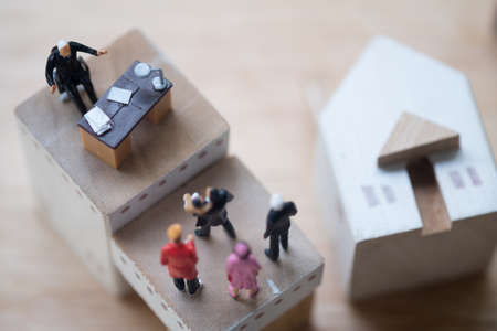 Miniature people : lawyer or financial advisor insurance broker or bank worker, concept of investment or taking loanの写真素材