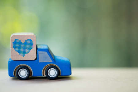 Miniature toy car carrying a heart delivering for Valentine's dayの写真素材