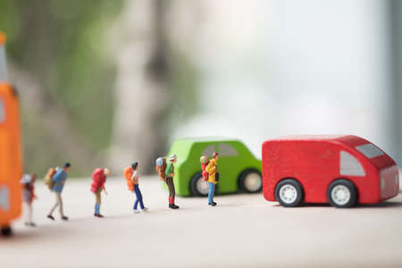 Miniature people : Group of traveler standing on road for hopping find passing car carrying to transfer station when in travel. Image use for travelの写真素材