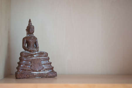 Select focus of ancient buddhas statue put on buddha shelf at house