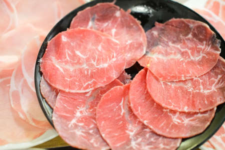 Cow beef sliced in thin pieces to be use in hot pot. Beef will be boiled for a couple or second only so it has to be thin.の写真素材