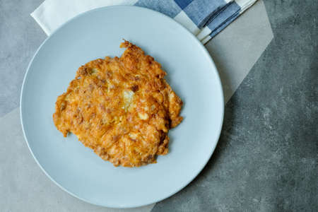 Crispy Thai omelet pork in blue ceramic plate. It's popular traditional, Thai style food