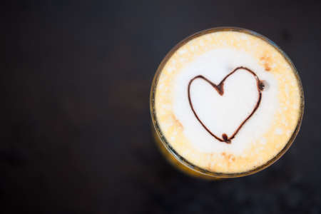 Heart shape on milk foam decorated with topping on iced drink
