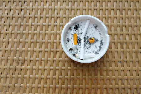 The cigarette butt is in the white ashtray, top viewの写真素材