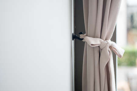 Part of beautifully draped curtain on the window in the roomの写真素材