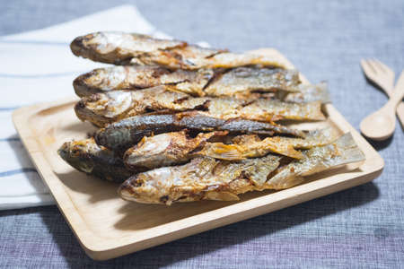 Fried mullet fish on wooden tray, Thai homemade foodの写真素材