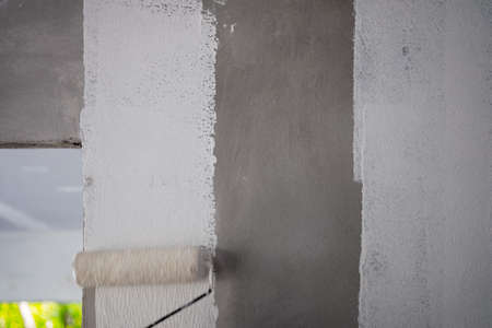 Painting color on building wall. Apartment renovation. Construction theme.