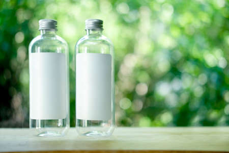 Plastic bottles packages with labels design for your business with blur nature background