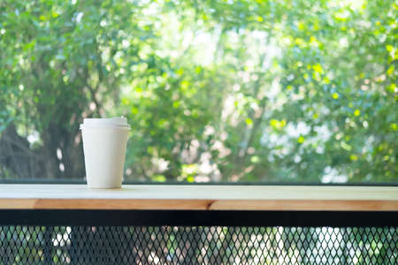 Paper coffee disposable cup for take away or to go put on wood tableの写真素材