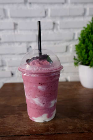 Tasty blueberry smoothie in glass on wooden tabelの写真素材