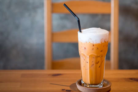 Iced milk tea or Thai milk tea in glass on the table.の写真素材