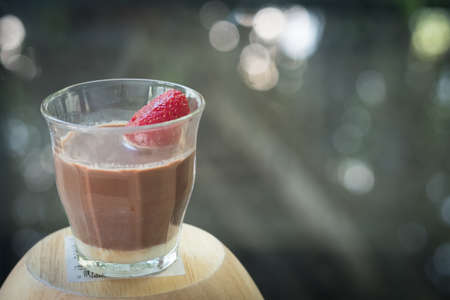 Glass of dark chocolate with fresh strawberry with blur backgroundの写真素材