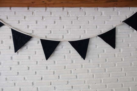 Black triangular flags hanging on white brick wall decoration in cafeの写真素材