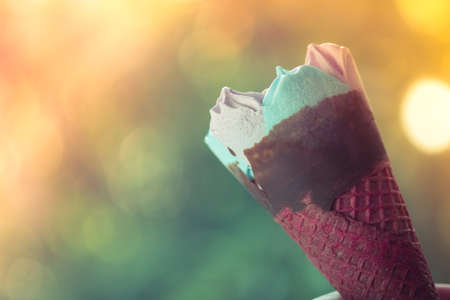 Ice cream pink wafer cone against on nature blur background