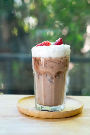 Chocolate drink with freeze strawberry and milk foam on top put on wood tableの写真素材
