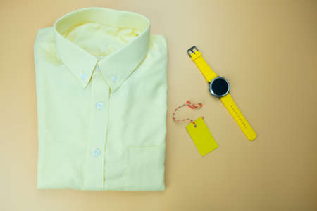 Official outfits for men clothing with yellow smart watch and tag name, flat lay backgroundの写真素材