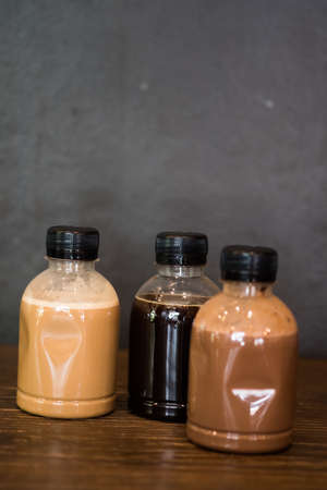 Three of plastic coffee bottle on wood tableの写真素材