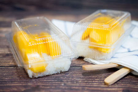 Sticky rice coconut milk with mango in clear plastic box is popular traditional dessert of Thailand