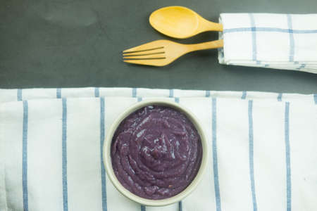 Homemade puree purple potato cream soup on a ceramic bowl