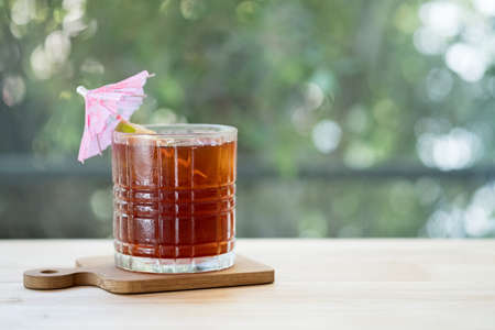 Iced tea with lemon on wooden table background with copy space. Summer iced drink