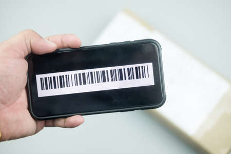 Shipping barcode on mobile phone screen with box. Concept of online delivery service, tracking online trackの写真素材