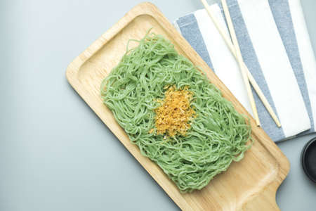 Green noodles with fried garlic on wooden tray (Jade noodles)(Jade noodles)