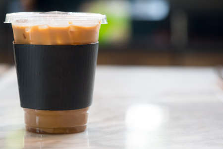 Iced coffee with black paper sleeve