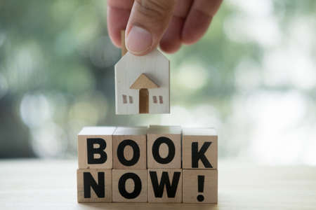 Man put and giving wooden house model on table. Real estate, buying moving new home or selling,...