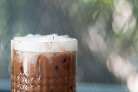 A cup of iced mocha, espresso mixed with chocolate or cocoa topped with milk foam on top of glass at coffee cafeの写真素材