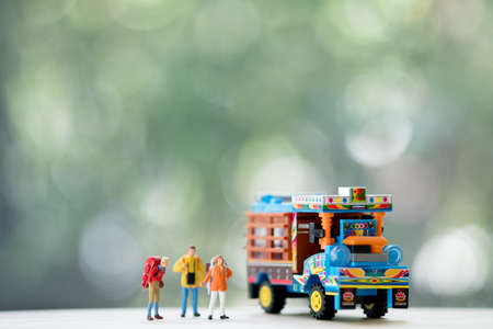 Miniature people : Traveler with backpack standing next to Thai farming trucks, Travel and Adventure...