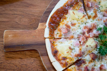 Delicious hot pizza on wooden board plate at Pizzeria restaurantの写真素材