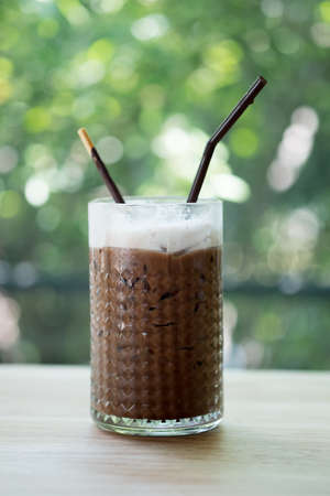 A cup of iced mocha, espresso mixed with chocolate or cocoa topped with milk foam on top of glass at coffee cafeの写真素材