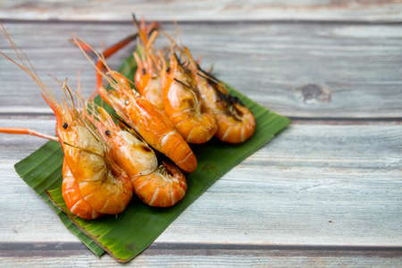 Grilled giant freshwater prawn on green banana leaf dishの写真素材