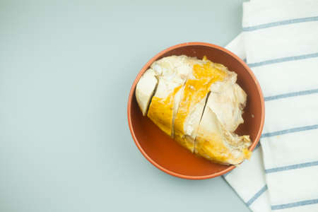 Tasty full roast chicken in orange bowlの写真素材