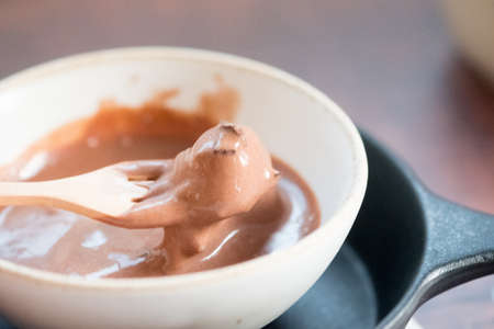 Silky smooth chocolate ice cream in a melting process in bowlの写真素材