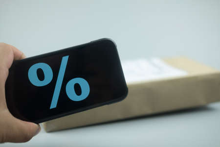 Smartphone with discount sign on screen in a shopping cart. Concept of online shoppingの写真素材