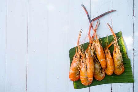 Group grilled giant freshwater prawn on green banana leaf backgroundの写真素材