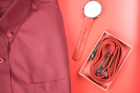 Red theme with shirt, smart watch and camera strap on red background