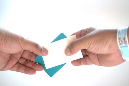 Hand with paper wristband and hold card payment for entrance to eventの写真素材
