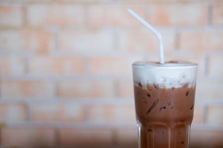 Tall cup of cold chocolate with fresh milk foam on topの写真素材