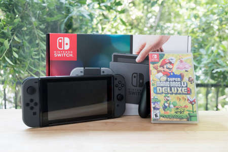 Bangkok, Thailand - June 10, 2019 : Nintendo Switch, video game console for home or portable gaming with box of Mario deluxe switch gameのeditorial素材